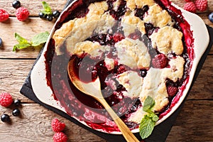 Berry cobbler with currants, raspberries and blueberries decorated with mint close up. Horizontal top view