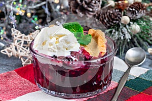 Berry cobbler in glass ramekin, garnished with ice cream, Christmas decoration, horizontal