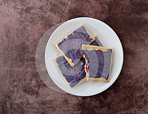 Berry flavor toaster pastry on a white dish broken in half
