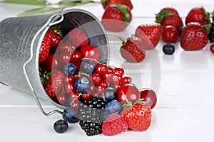 Berry fruits in bucket with strawberries, blueberries, cherries