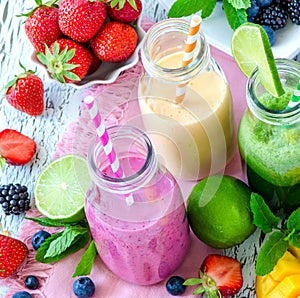 Berry and fruits smoothie in bottles, healthy summer detox yogurt drink, diet or vegan food concept