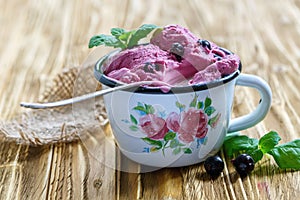 Berry ice cream with black currant in an enamel bowl.