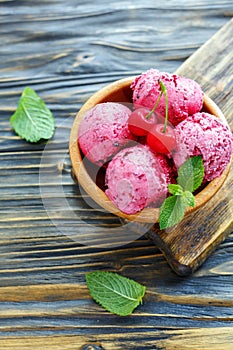 Berry ice cream with cherries in a wooden bowl.