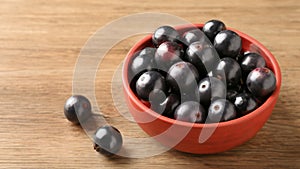 Berry Jaboticaba in bowl on wooden table. Generative AI