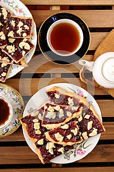 Berry jam cookies in white plate, two cup of tea, white teapot o