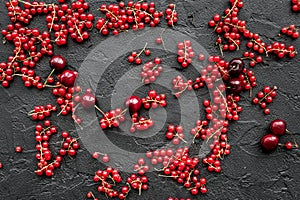 Berry theme. Red currant and cherry on black table background top view