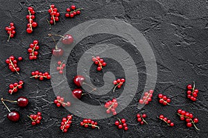 Berry theme. Red currant, cherry on black table background top view copyspace