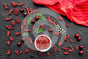 Berry theme. Red currant, cherry and leaves on black table background top view mockup