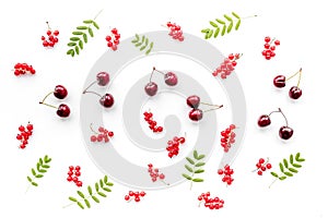 Berry theme. Red currant, cherry and leaves on white background top view