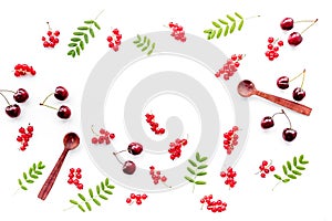 Berry theme. Red currant, cherry, wooden spoons and leaves on white background top view copyspace