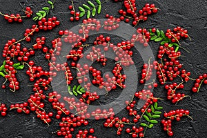 Berry theme. Red currant and leaves on black table background top view