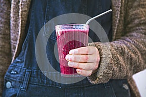 Berry vegan smoothie with chia seeds, glass of healthy smoothie in female hands