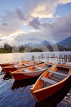 Berth with boats on a mountain lake in the rays of the sunset