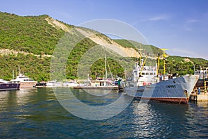 Berth with boats. Mountains.