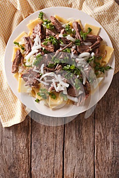 Beshbarmak dish: noodles with lamb and onion. Vertical top view