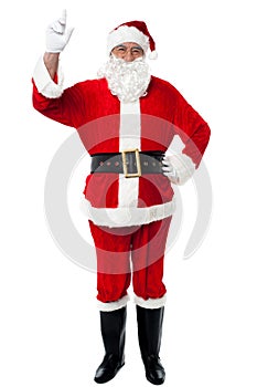 Bespectacled Santa pointing upwards