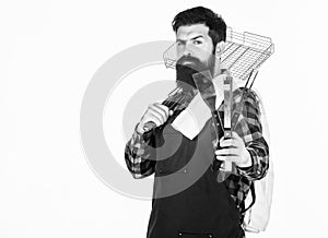 The best bbq in the city. Grill cook holding portable bbq tools. Bearded man with bbq grid and cooking tools in hands