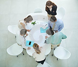 The best brains in the business. High angle shot of a group of businesspeople meeting in the office.