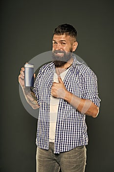 The best care ever. Bearded man showing thumbs up for hair care product on grey background. Happy hipster liking his