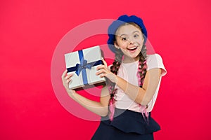 Best christmas gifts. Child excited about unpacking her gift. Kid little girl hold gift box with ribbon on red