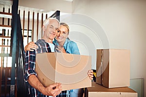 Best decision we made was buying a new house. Portrait of a happy mature couple carrying boxes on moving day.