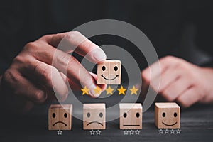 Best excellent business services rating customer experience. Satisfaction survey concept. Hand of a businessman chooses a smiley f