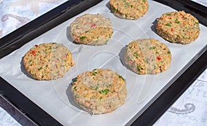 Best fish cakes raw uncooked on  baking tray. .Row of crab patties
