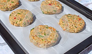 Best fish cakes raw uncooked on  baking tray. .Row of crab patties photo