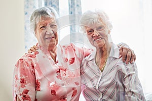 Best friends are the best things in life. Portrait of two happy elderly women embracing each other at home.