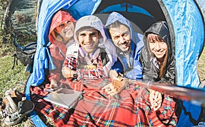 Best friends couples taking selfie at camping tent on sunny day