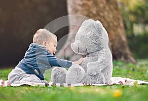 Best of friends. Cute toddler playing outdoors with his teddy bear