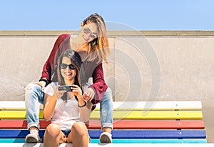 Best friends girlfriends enjoying time together outdoors with smartphone
