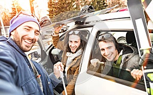 Best friends having fun taking selfie at car with ski and snowboard
