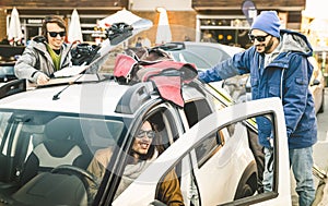 Best friends having fun together preparing car for ski and snowboard