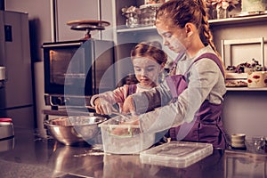 Nice serious girls preparing a cake together