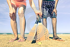 Best friends ready to play beach tennis game in summer