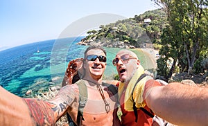 Best friends taking selfie at Giglio Island on adventure travel - Wanderlust lifestyle concept with gay couple enjoying happy fun photo