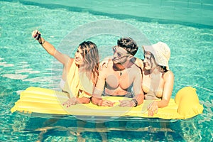 Best friends taking selfie at swimming pool with yellow airbed photo