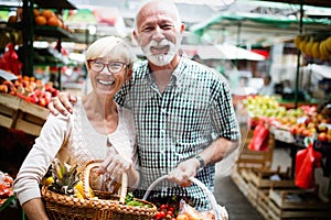 Only the best fruits and vegetables. Beautiful mature couple buying fresh food on market