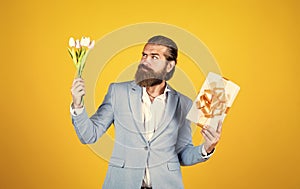 best gift ever. true gentleman with bouquet. love date concept. bearded man in formalwear with tulip flowers and box
