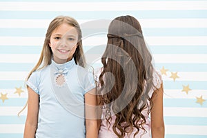 Best hairstyles for long hair. Cute small girls with long brunette and blond curls in playroom. Adorable little children