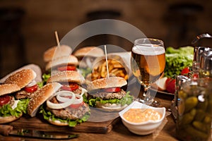 Best happy hour burgers with cold beer on a restaurant wooden table