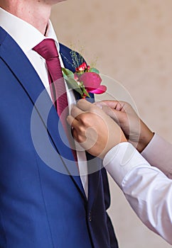 Best Man Adjusting Groom's Boutonniere close-up