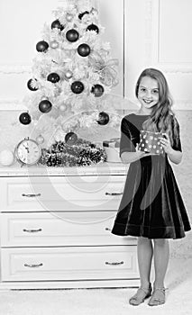 Best for our kids. Kid girl near christmas tree hold gift box. Child celebrate christmas at home. Favorite day of the