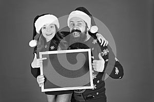 Best product to sell at Christmas. Happy family presenting product at empty blackboard. Bearded man and small child