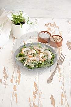 Salad with arugula, shrimps, parmesan cheese and pine nuts