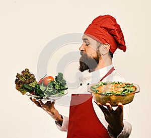 Best salads from chef. Handsome waiter or cook in uniform photo