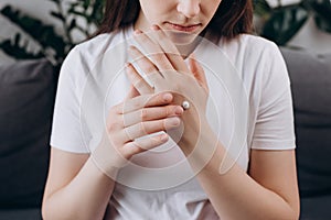 Best Skin Moisturizer. Close up of beautiful young caucasian woman applying hand cream. Attractive millennial lady client do daily
