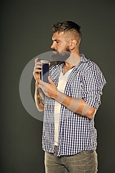 Best smelling gel. Hipster with long beard holding gel bottle on grey background. Bearded man with stylish hair smelling