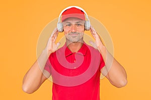 Best sounding headphones. Happy guy wear headphones yellow background. Handsome man listen to music in headphones. Using